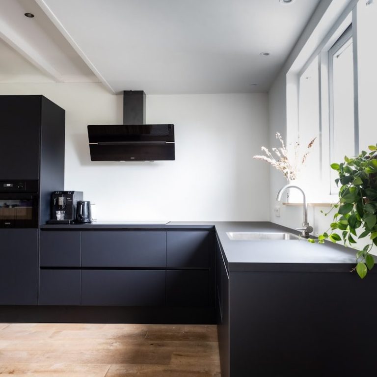 Modern black kitchen with sleek cabinets, a stainless steel sink, Poole